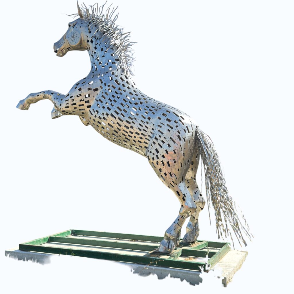 Cheval monumental en inox – Galain L’artiste Galain signe ici une œuvre monumentale en inox, pensée pour dialoguer avec l’espace extérieur. Cette sculpture représente un cheval puissant et élancé, dont les lignes épurées et la surface réfléchissante captent la lumière et transforment l’environnement au fil de la journée. L’inox, matériau à la fois contemporain et intemporel, confère à l’œuvre une présence forte, presque vivante. Entre force et élégance, cette création incarne la liberté, le mouvement et la noblesse de l’animal, tout en s’inscrivant dans une esthétique résolument moderne.