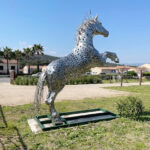Une œuvre qui capte le regard… et la lumière. Avec ce cheval monumental en inox, Galain explore l’équilibre entre puissance et finesse. La matière réfléchissante joue avec l’environnement, faisant évoluer la perception de la sculpture au fil des heures et des saisons. Pensée pour l’extérieur, cette œuvre s’intègre naturellement dans son espace tout en affirmant une présence forte et contemporaine. Une vision moderne et intemporelle du cheval, symbole de liberté et d’énergie.