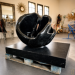 Sculpture en marbre noir représentant une rose en pleine éclosion, aux formes organiques et enveloppantes. Cette œuvre joue avec la matière et la lumière, révélant des courbes profondes et une présence presque sensuelle. Pièce décorative forte, idéale en intérieur comme en extérieur.