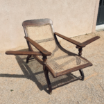 Fauteuil Planter's Chair style colonial en bois exotique et cannage.