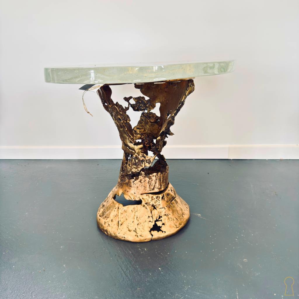 Par les artistes Nico Tournaire & Jean-Marie Le Goff Sculpture fonctionnelle mêlant art et design, “Tam Tam” est une œuvre singulière née de la collaboration entre le sculpteur français Nico Tournaire et le maître verrier Jean-Marie Le Goff. Le piètement en bronze poli, aux formes organiques et presque volcaniques, révèle tout le travail de matière cher à Nico Tournaire : un jeu puissant entre pleins et vides, surfaces brutes et reflets métalliques. Le plateau en verre signé Jean-Marie Le Goff apporte quant à lui transparence, légèreté et profondeur à l’ensemble. Cette pièce rare dialogue entre feu, métal et verre dans une esthétique minérale et poétique.
